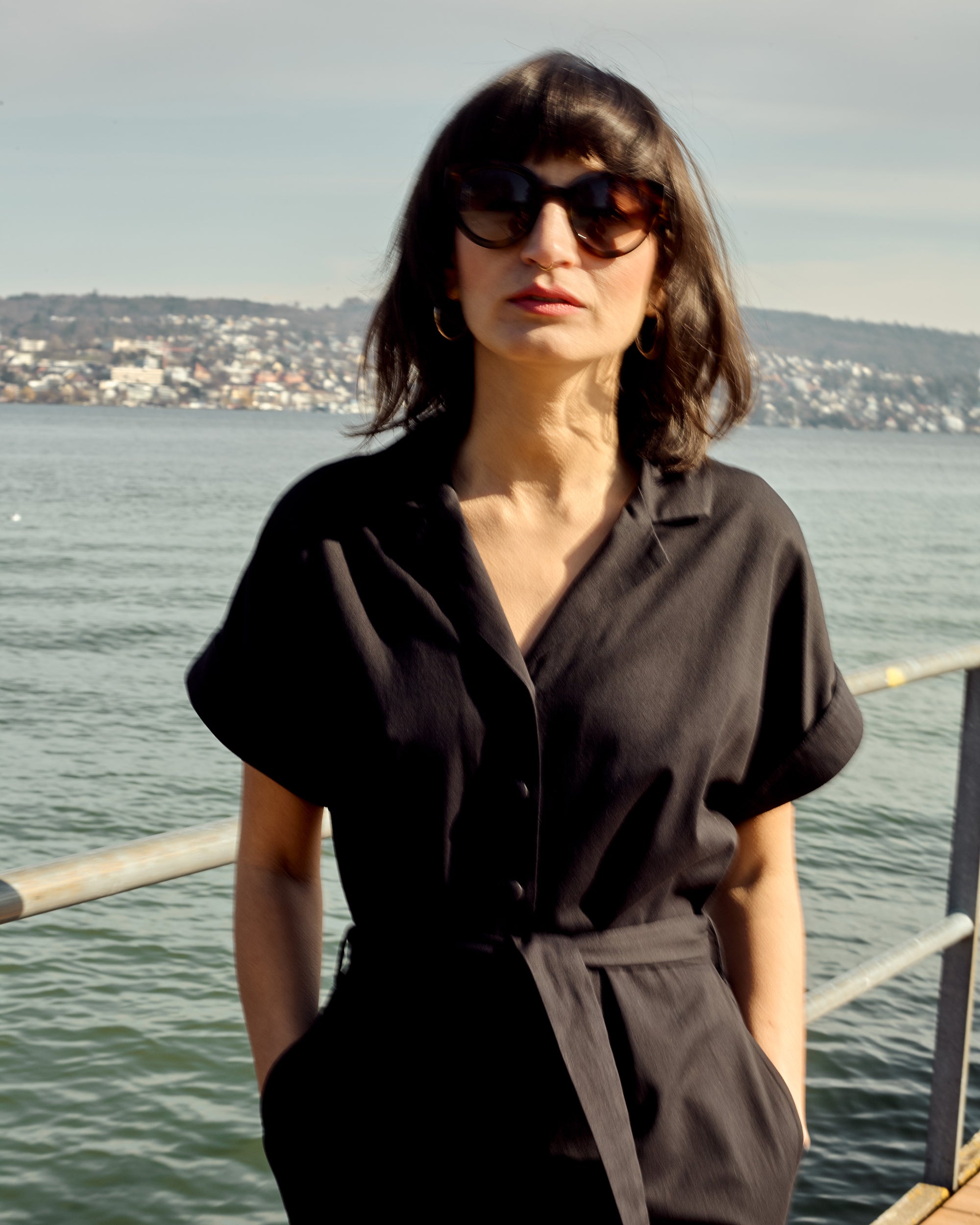 Editorial close-up of petite black jumpsuit in organic cotton twill.