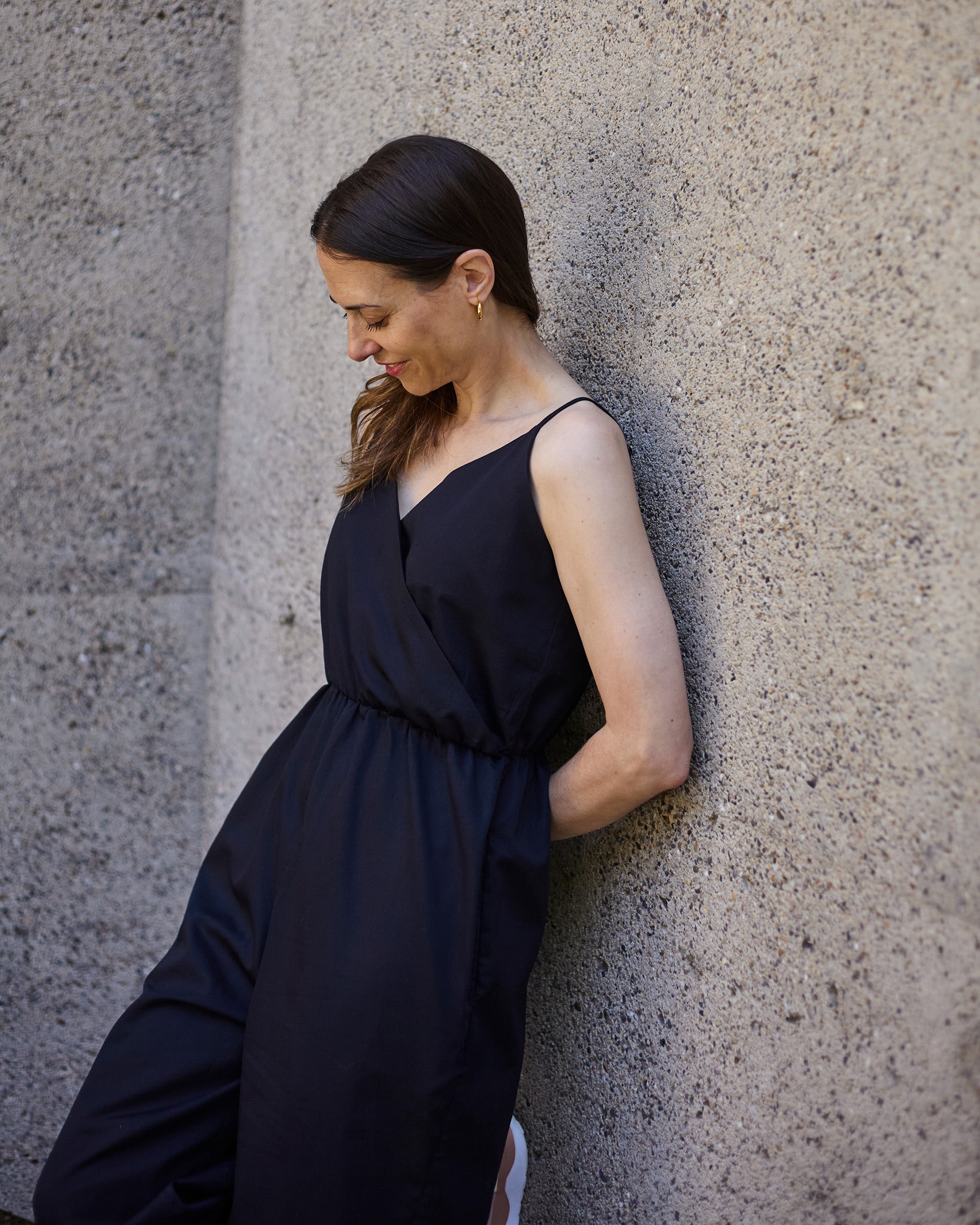 Side view of petite black wrap jumpsuit with relaxed fit and elasticated waist.