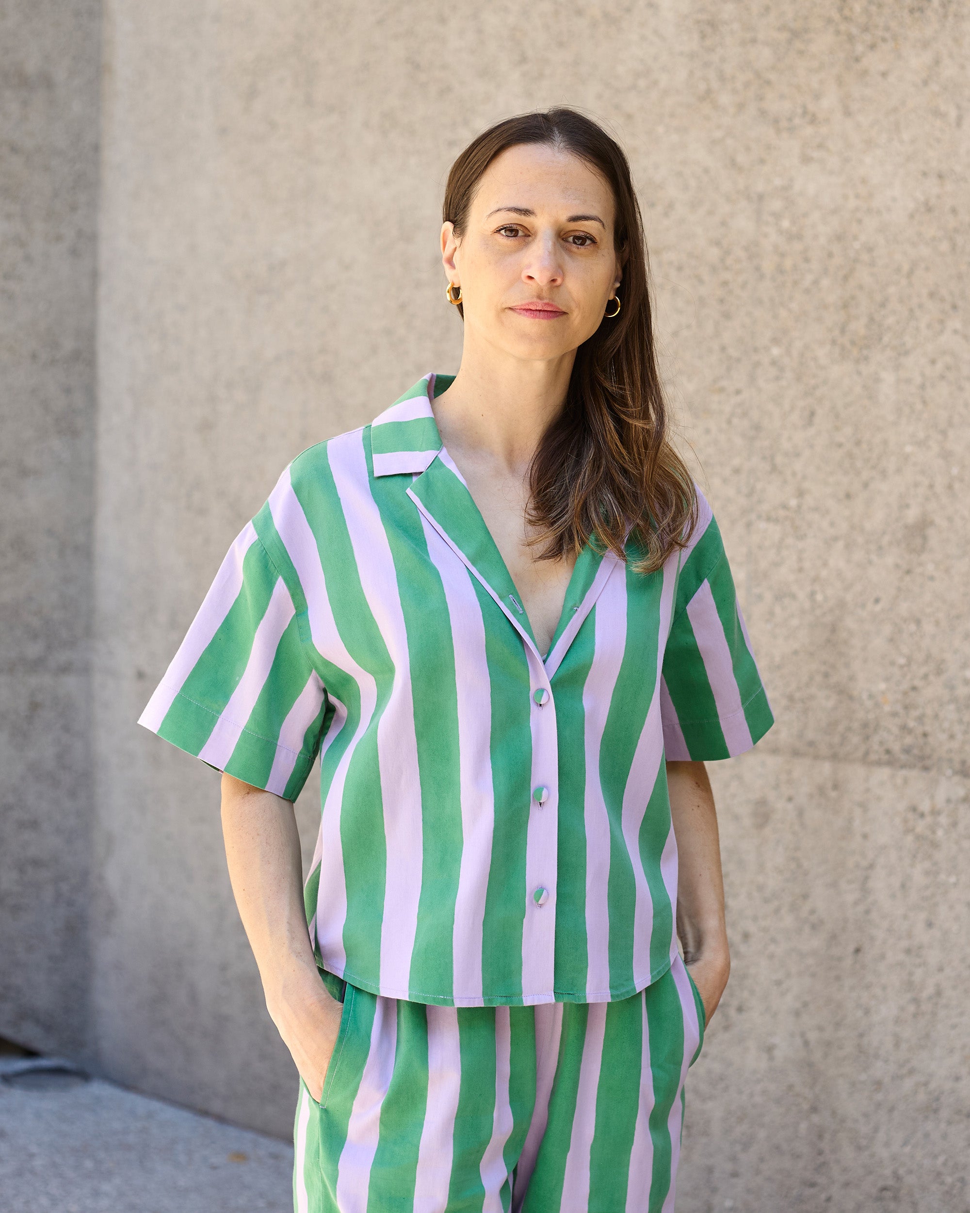 Model wearing petite blockprint blouse in green and lilac stripes.