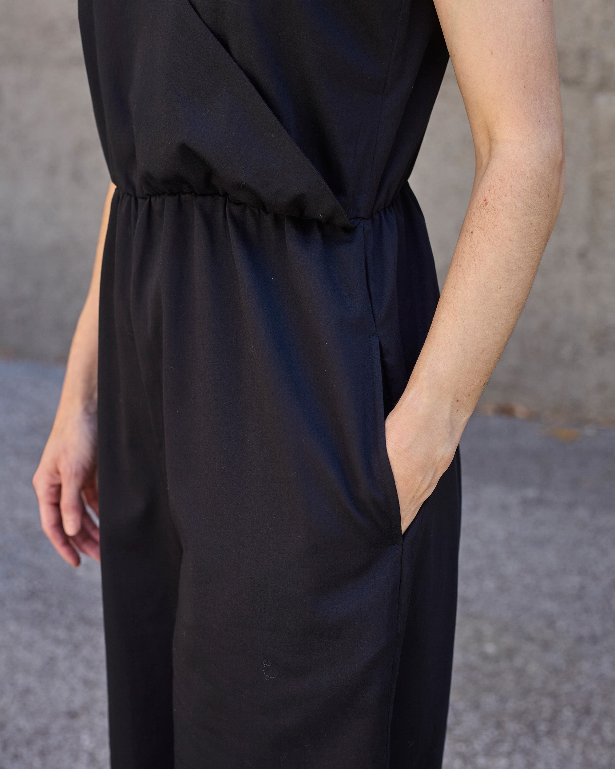 Detail of side pocket and elasticated waist on petite black wrap jumpsuit.