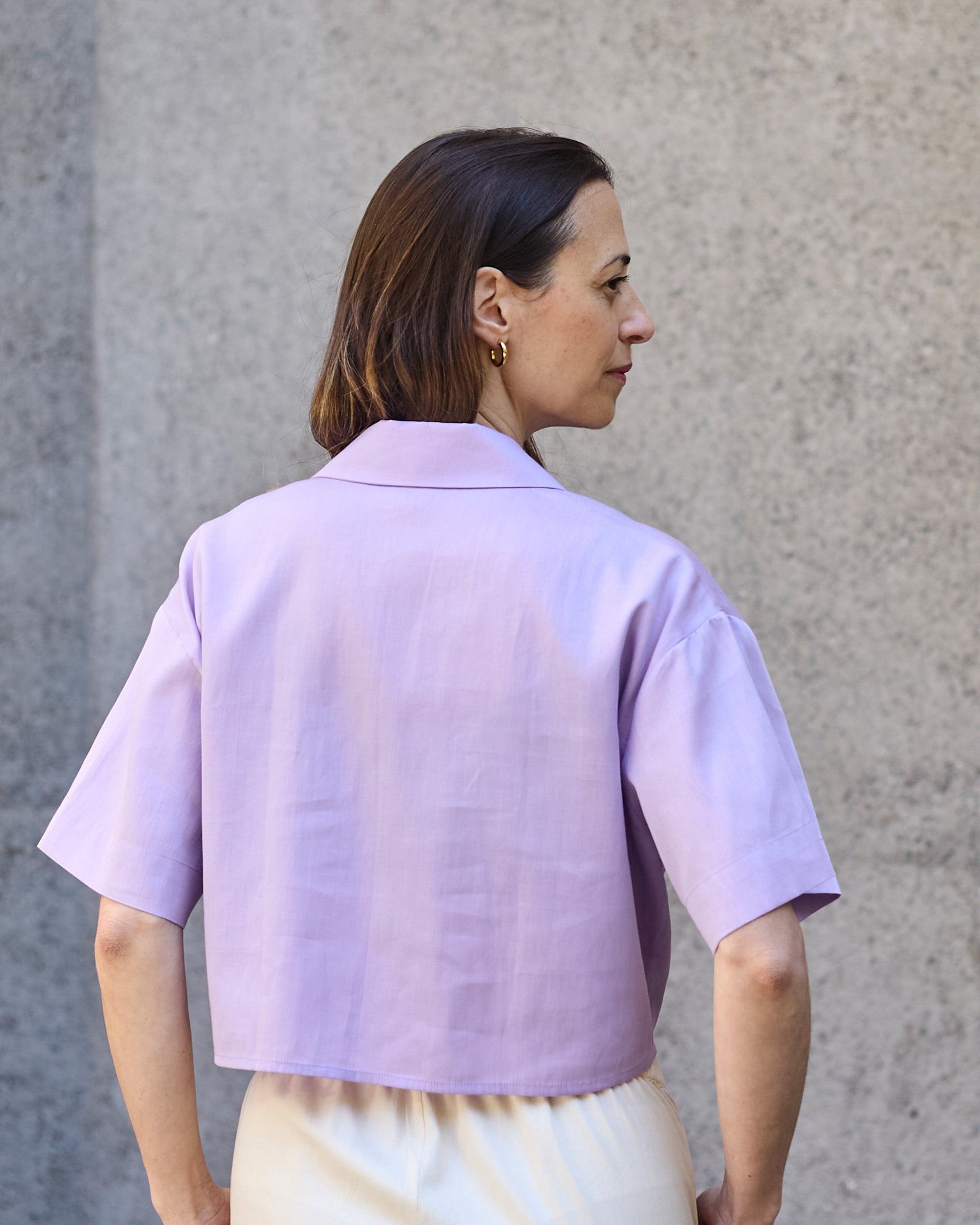Back view of a petite model wearing the Wrap Blouse Lilac.